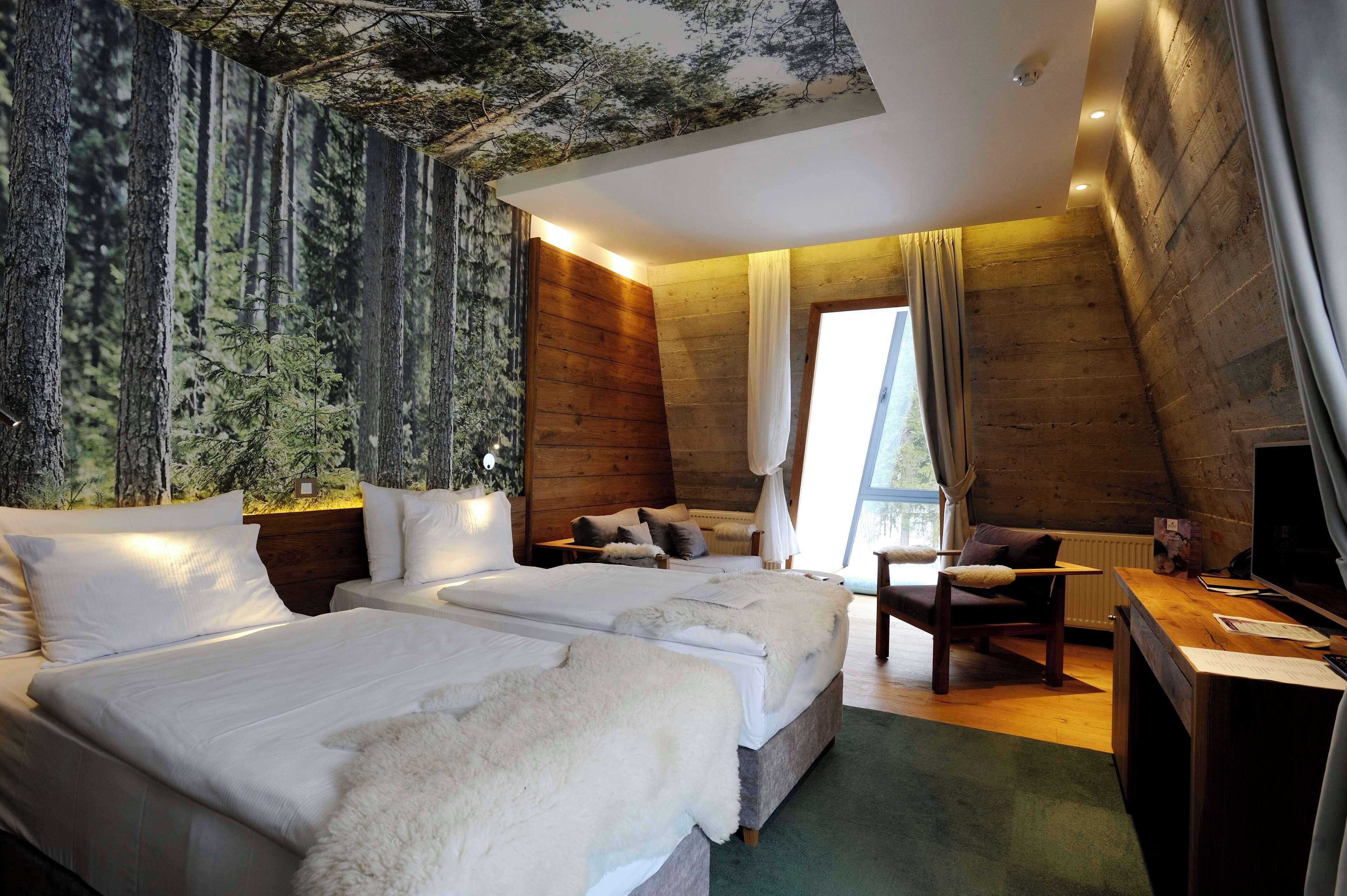 A bedroom with two beds, a desk, and a chair.