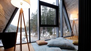 A room with a large window, a floor lamp, and a rug with pillows. - Pino Nature Hotel, BW Premier Collection (Sarajevo)