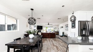 Eine moderne Küche mit einem Holztisch, weißen Schränken und Edelstahlgeräten.