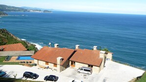 Une propriété située sur la côte, avec un bâtiment en pierre, une piscine et une vue sur la mer.
