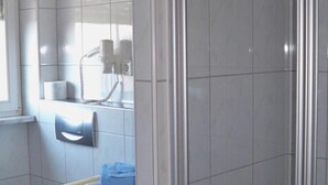A bathroom with a toilet, sink, and a shower area. - Hotel Waldeck Garni (Kist)