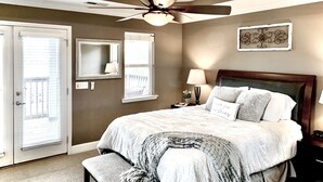 A bedroom with a bed, a ceiling fan, a window, a nightstand, and a wall-mounted mirror. - Enjoy a spacious private residence loaded with amenities. Minutes to everything! (Nashville)