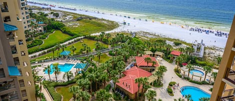 A resort with a beach, swimming pools, and a view of the ocean.