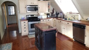 A kitchen with wooden cabinets, a microwave, stove, and dishwasher.