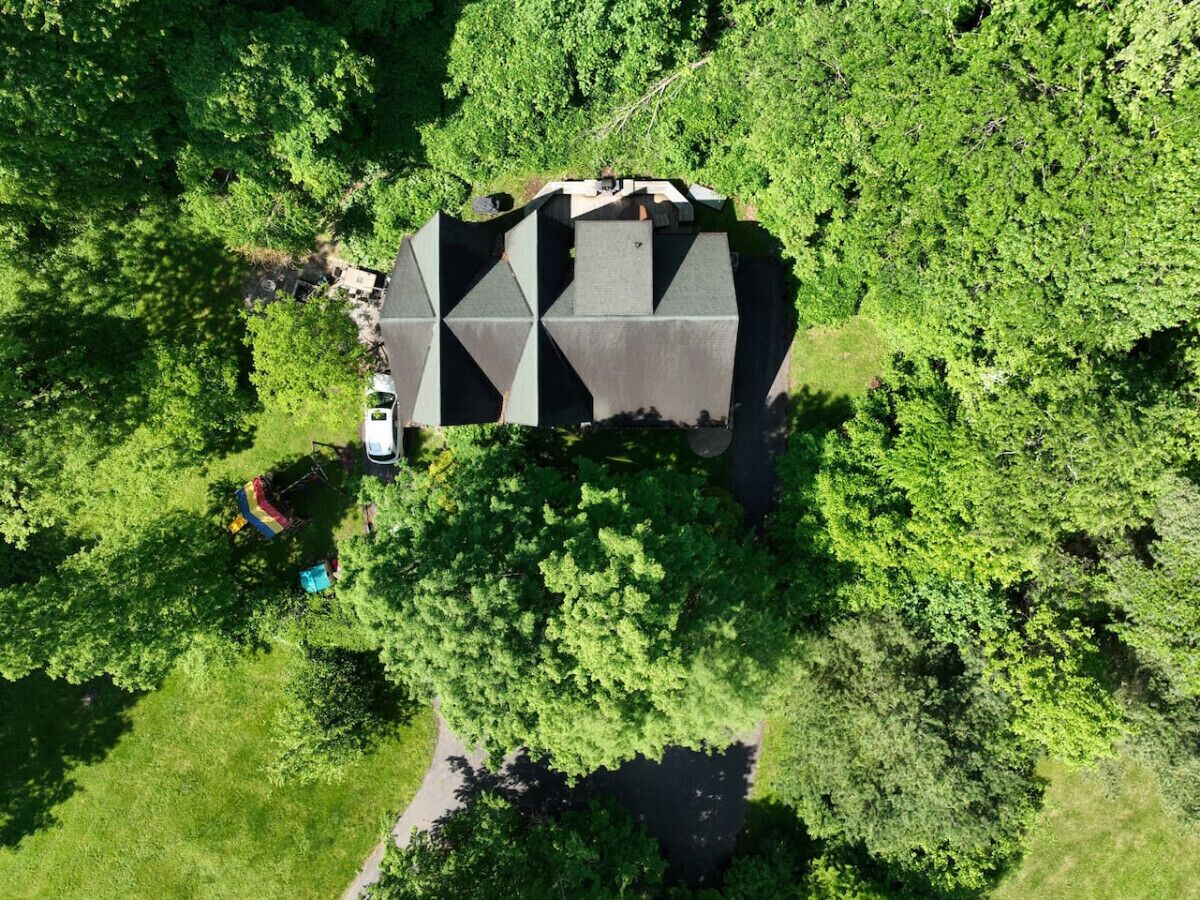 Een luchtbeeld van een uniek, geometrisch gebouw, omringd door weelderige groene beplanting.