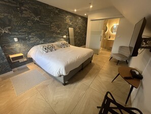 Een moderne slaapkamer met een groot bed, een bureau en een stoel.