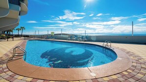 A swimming pool with a clear blue sky and a sun in the background.