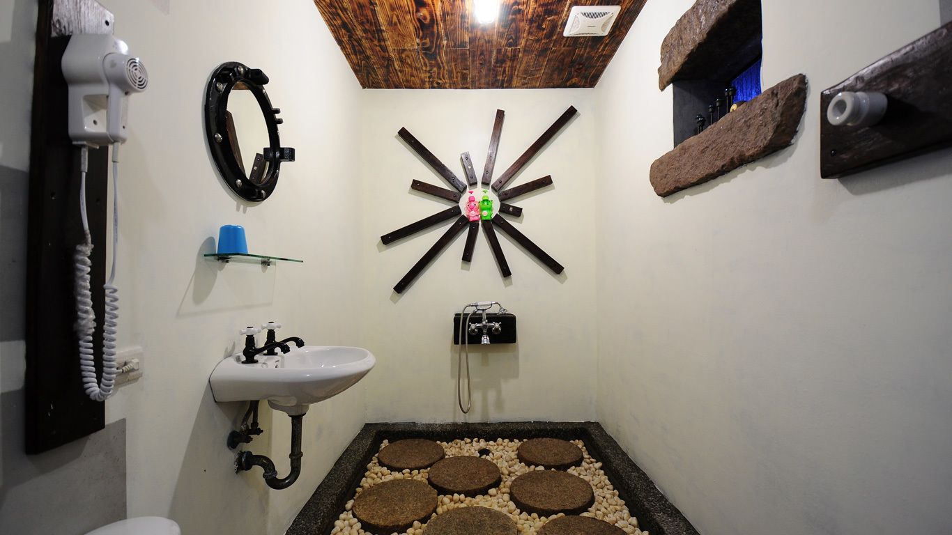 A bathroom with a white sink, a mirror, a hairdryer, and a unique wooden star-shaped light fixture.