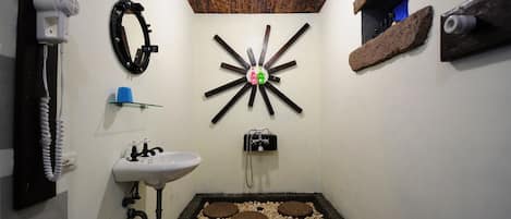 A bathroom with a white sink, a mirror, a hairdryer, and a unique wooden star-shaped light fixture.