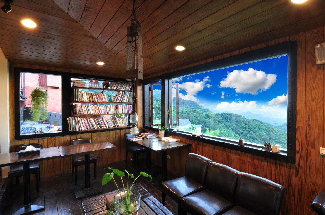 Un coin lecture confortable avec des murs en bois, une grande bibliothèque et une vue sur un paysage montagneux.