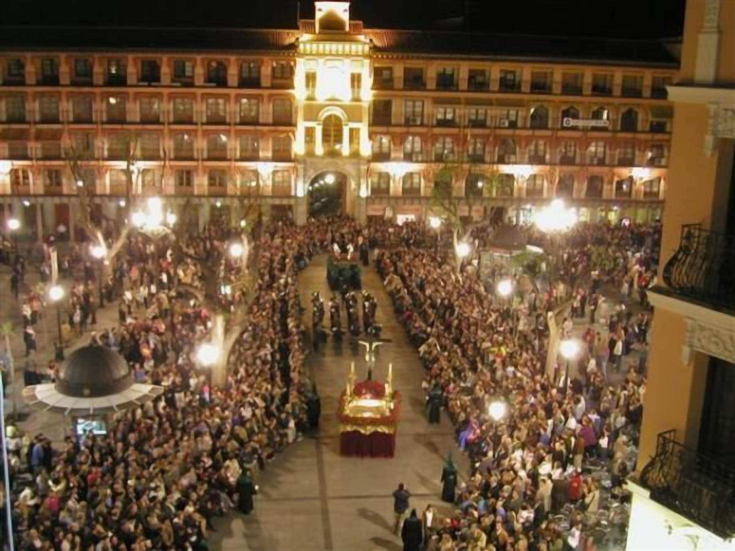 Una amplia plaza abierta con un escenario central y una multitud de personas.