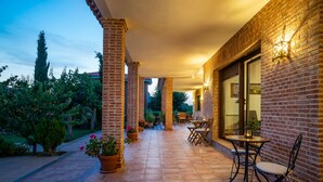 Un espace patio avec des murs en briques, un sol carrelé et du mobilier d’extérieur.