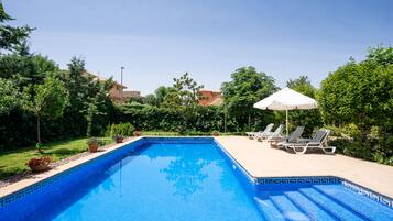 Una piscina al aire libre, tumbonas