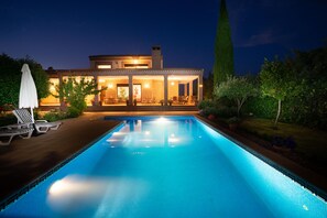 A modern house with a swimming pool, outdoor furniture, and a well-lit patio area. - B&B Villa Marín Toledo (Nambroca)