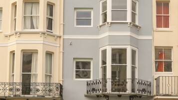 A row of townhouses with bay windows and a front door.