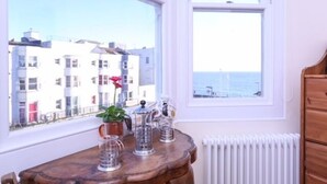 A room with a view of buildings and the sea through large windows. - Marina by the Sea B&B (Brighton)