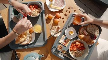 Un plateau de petit-déjeuner contenant divers aliments, notamment du pain, des œufs et des fruits.