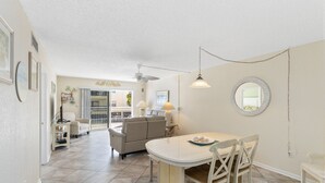 Un vaste espace de vie comprenant une table à manger, des chaises et un ventilateur de plafond.