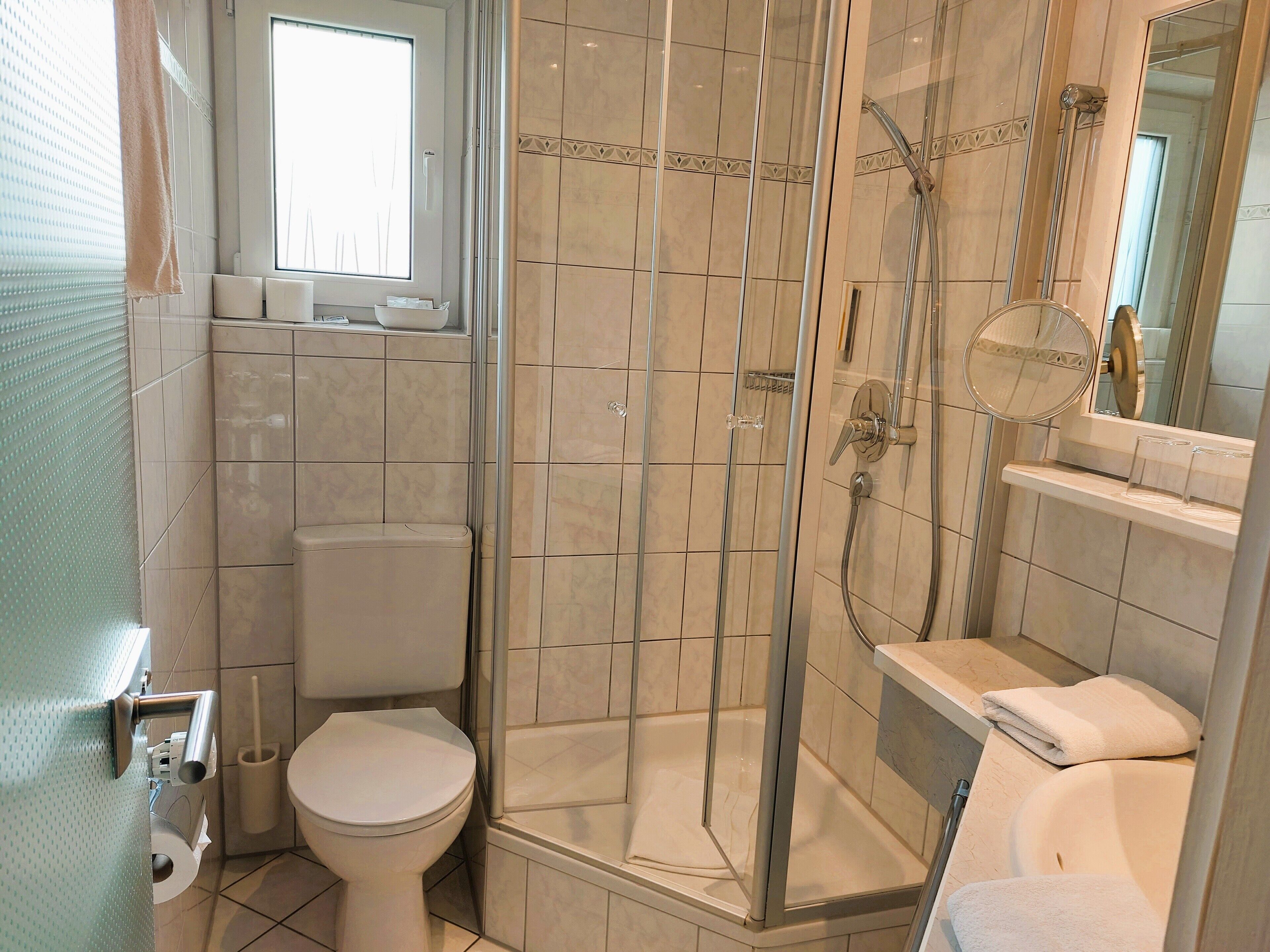 Une salle de bain avec une douche à parois de verre, des toilettes et une baignoire.