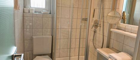 Un baño con ducha de vidrio, inodoro y bañera.