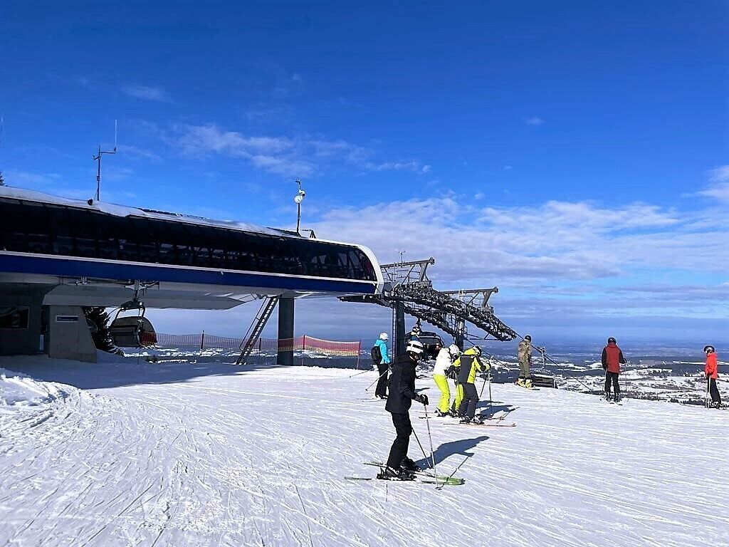A ski lift station with skiers waiting.