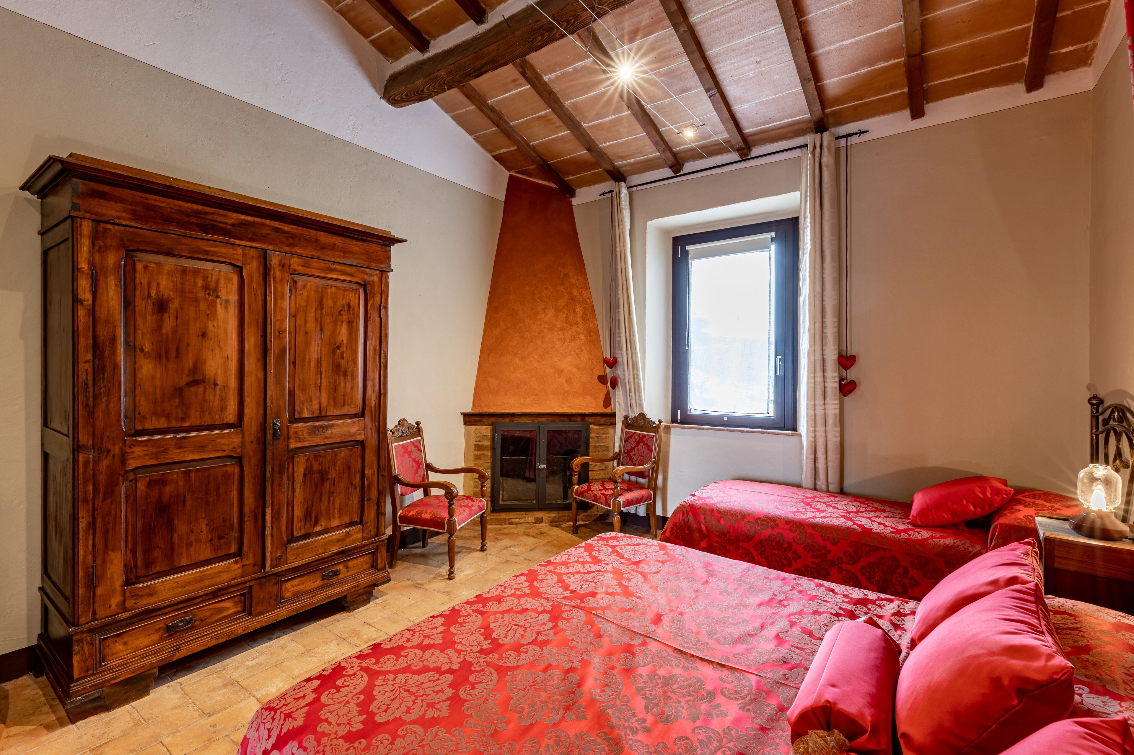 Ein Schlafzimmer mit zwei Betten, einem Holzschrank und einem Kamin.