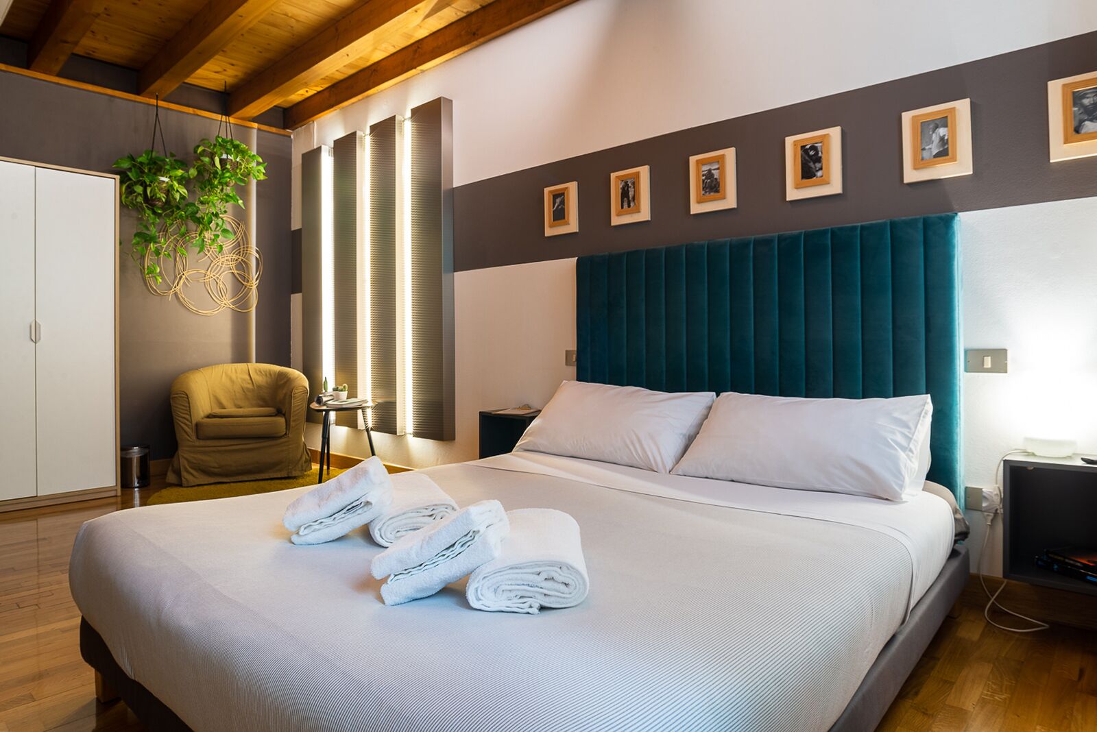 Une chambre d’hôtel moderne avec un grand lit, un canapé, un bureau et une fenêtre équipée de stores.