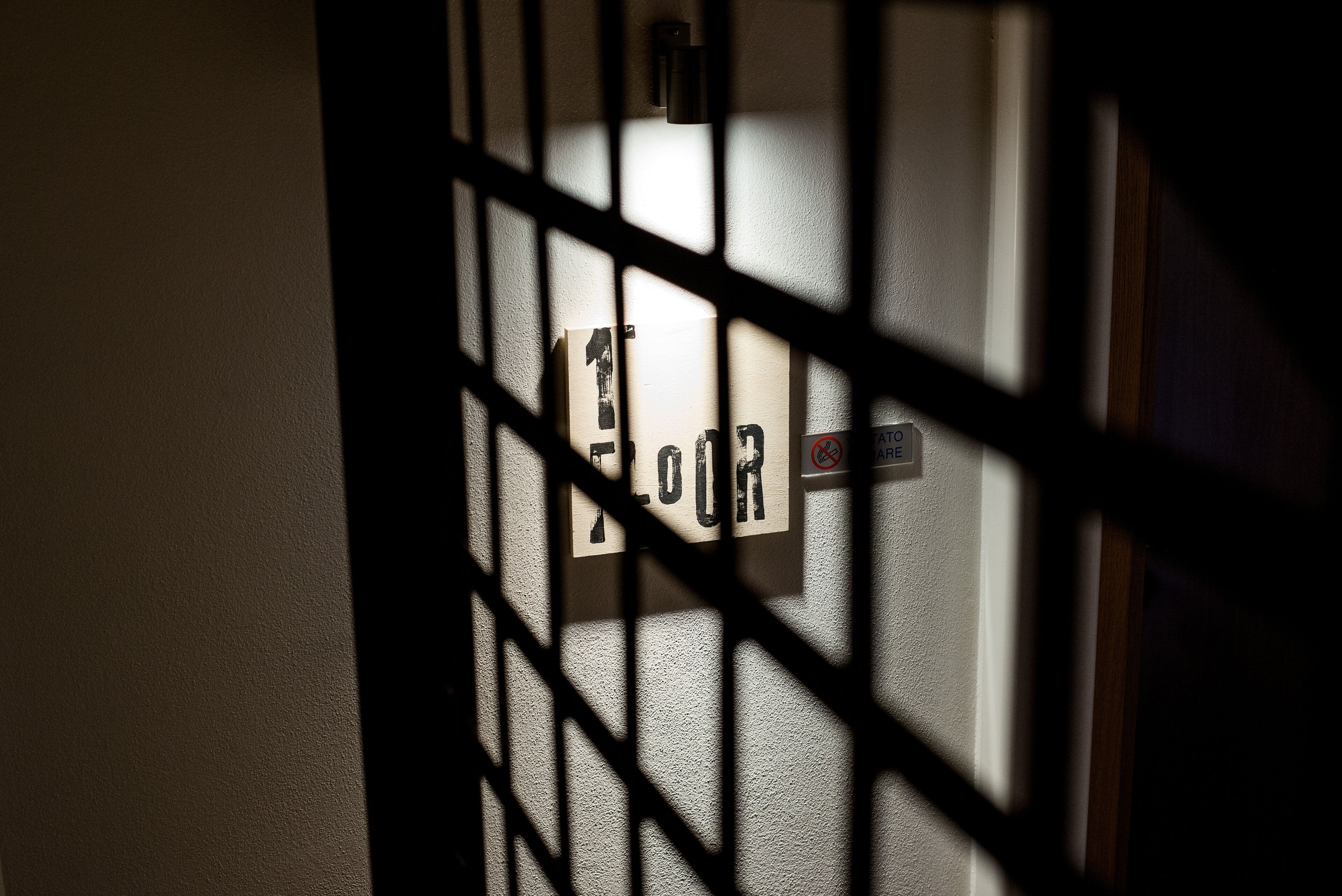 Una puerta con un cartel que dice "FLOR" parcialmente cubierta por una reja metálica.