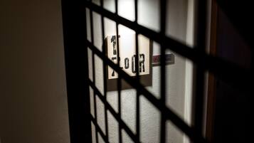 Una puerta con un cartel que dice "FLOR" parcialmente cubierta por una reja metálica.