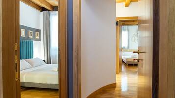 Une chambre d’hôtel avec un lit, une salle de bain avec un miroir et un couloir menant à une autre pièce.