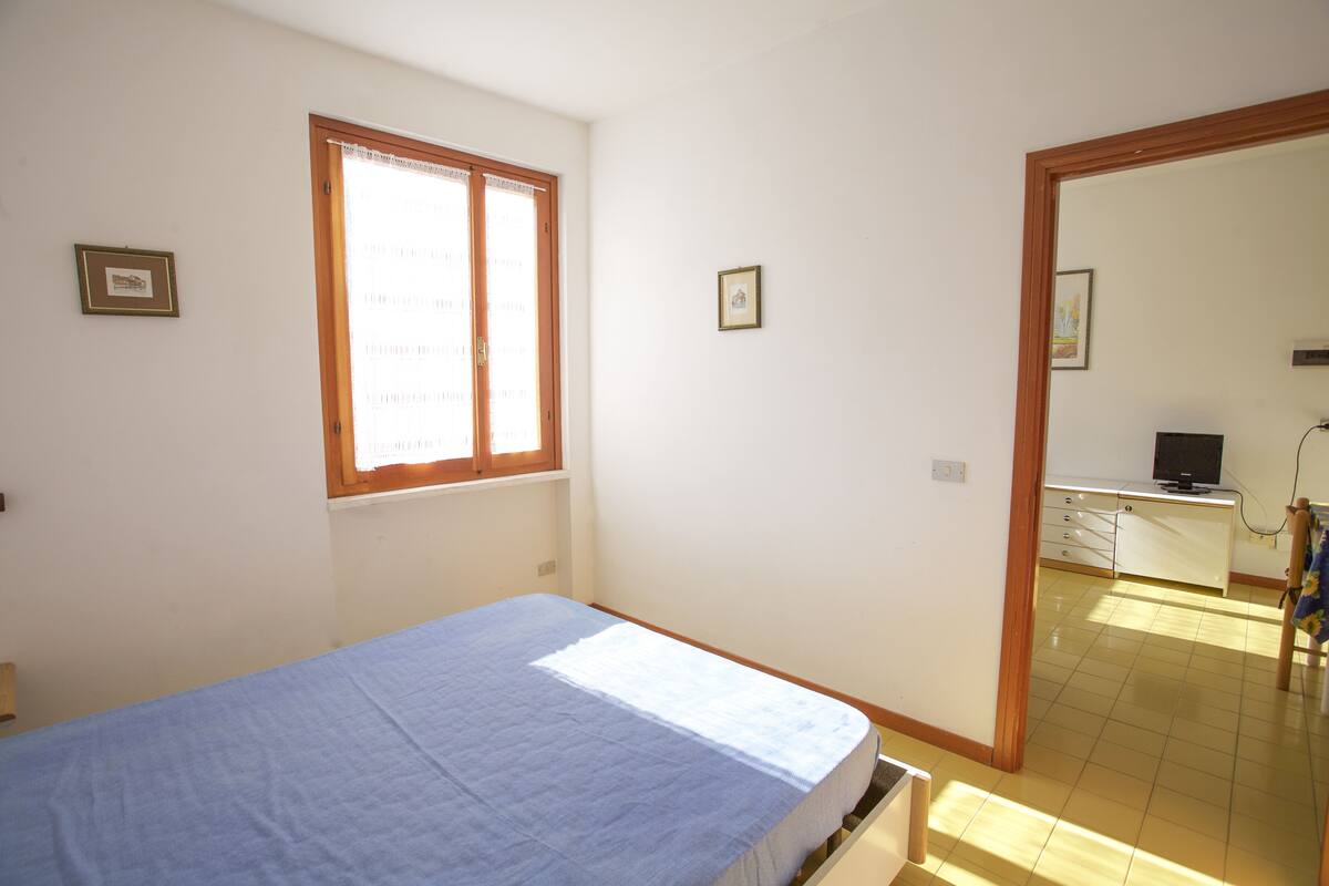 Une chambre à coucher avec un lit, une fenêtre, un bureau et une chaise.