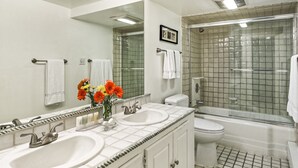 Ein Badezimmer mit zwei Waschbecken, einer Toilette und einer Dusche.