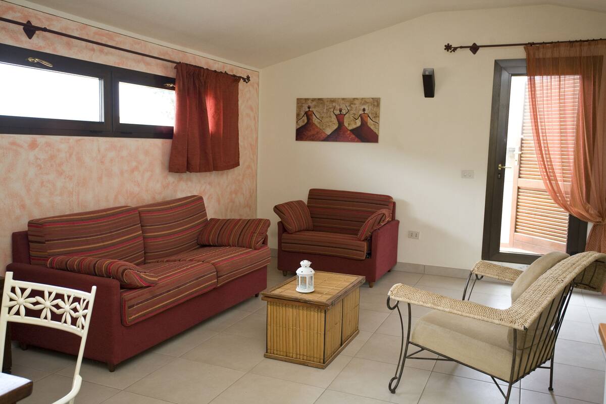 Una sala de estar con dos sofás, una mesita y una silla.