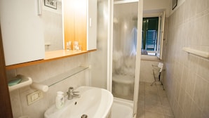 A bathroom with a sink, mirror, and shower. - Appartamento Bilo Amore (Portoferraio)
