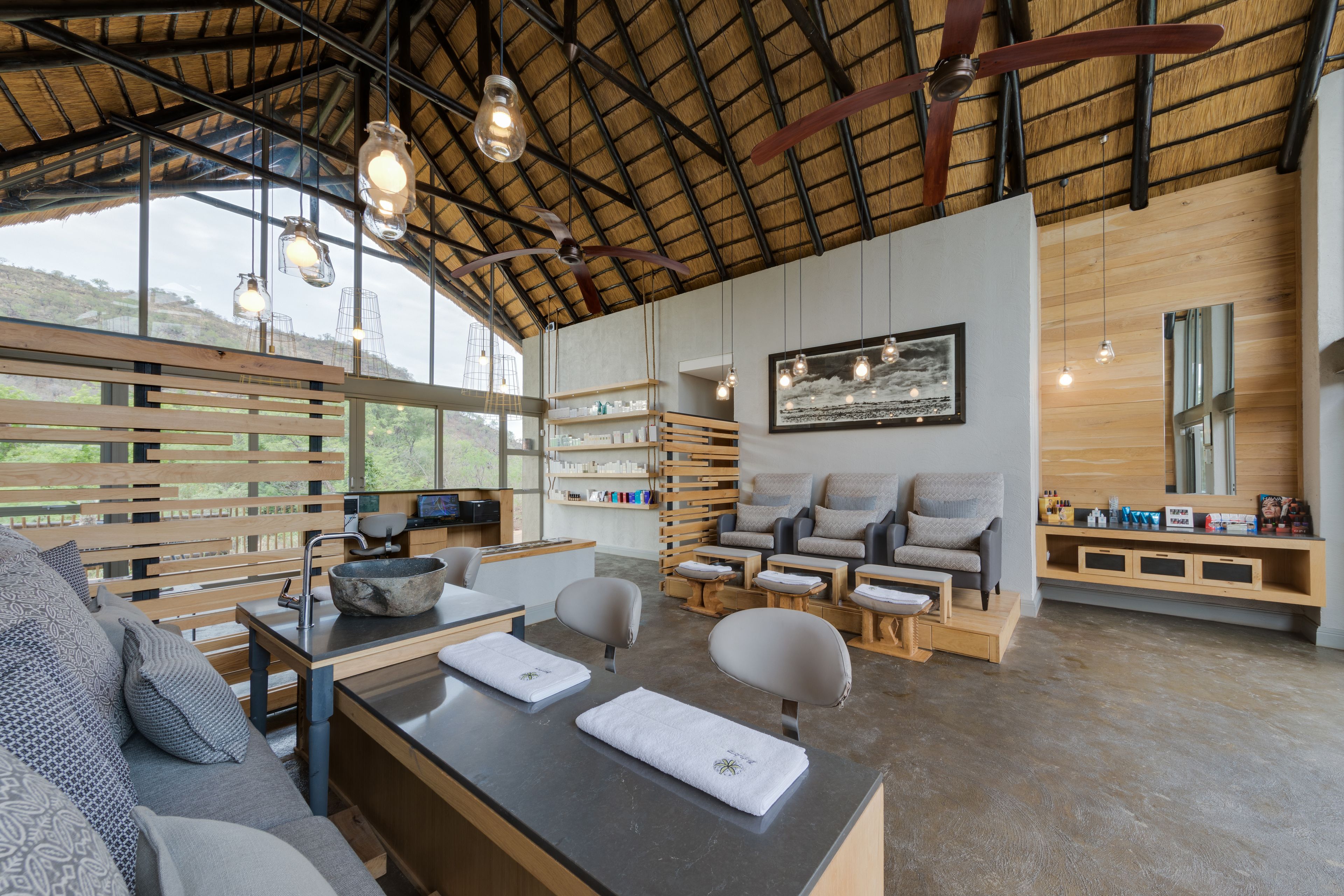 Un spa moderno con muebles de madera, un mostrador de recepción y un ventanal con vistas al exterior.
