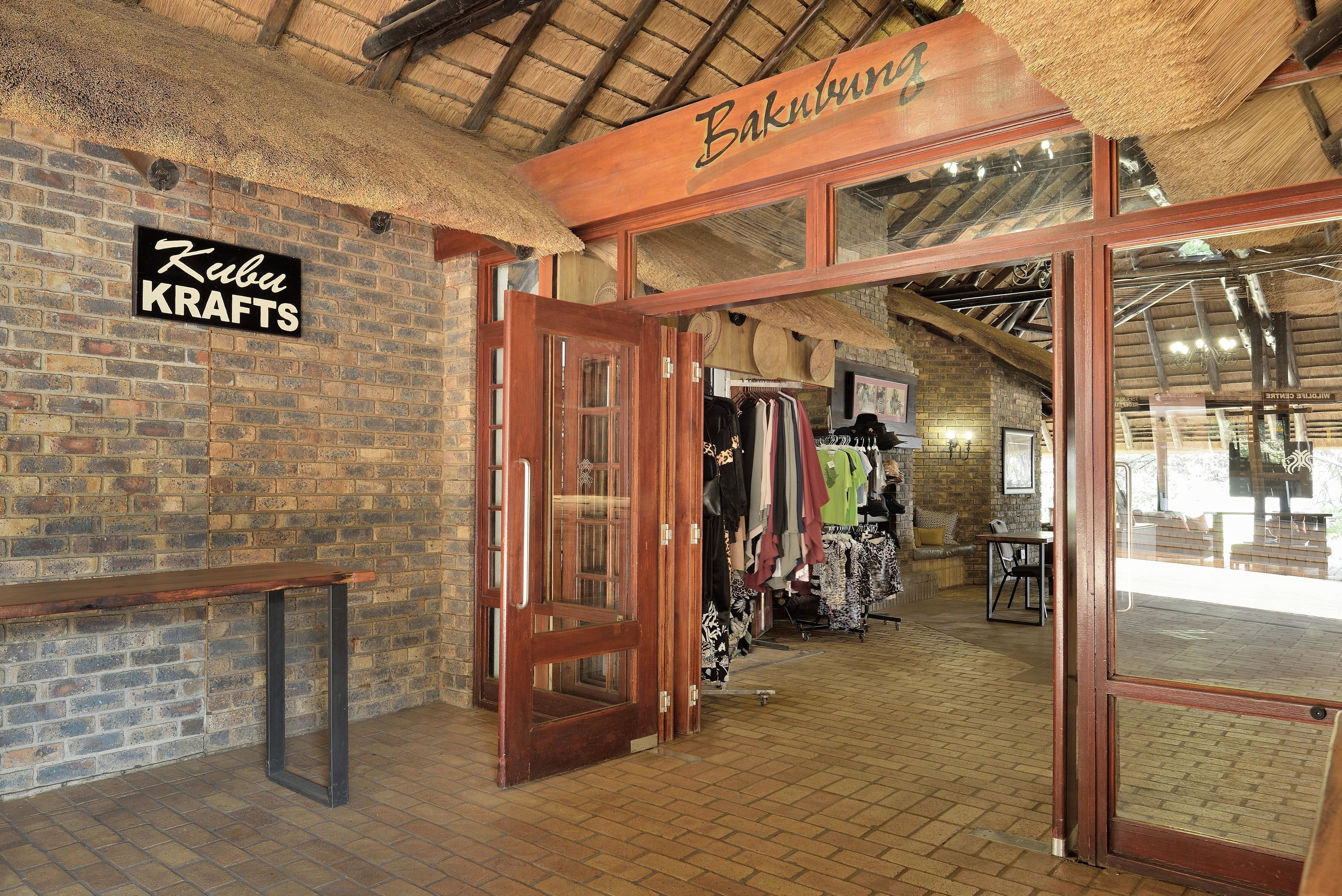 A rustic interior with exposed brick walls, wooden beams, and a sign reading "Baku KRAFTS".