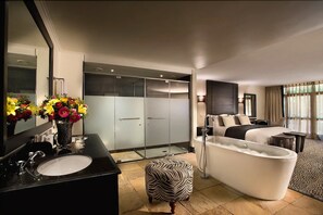 A modern bathroom with a freestanding bathtub, a large mirror, and a vanity with a sink.