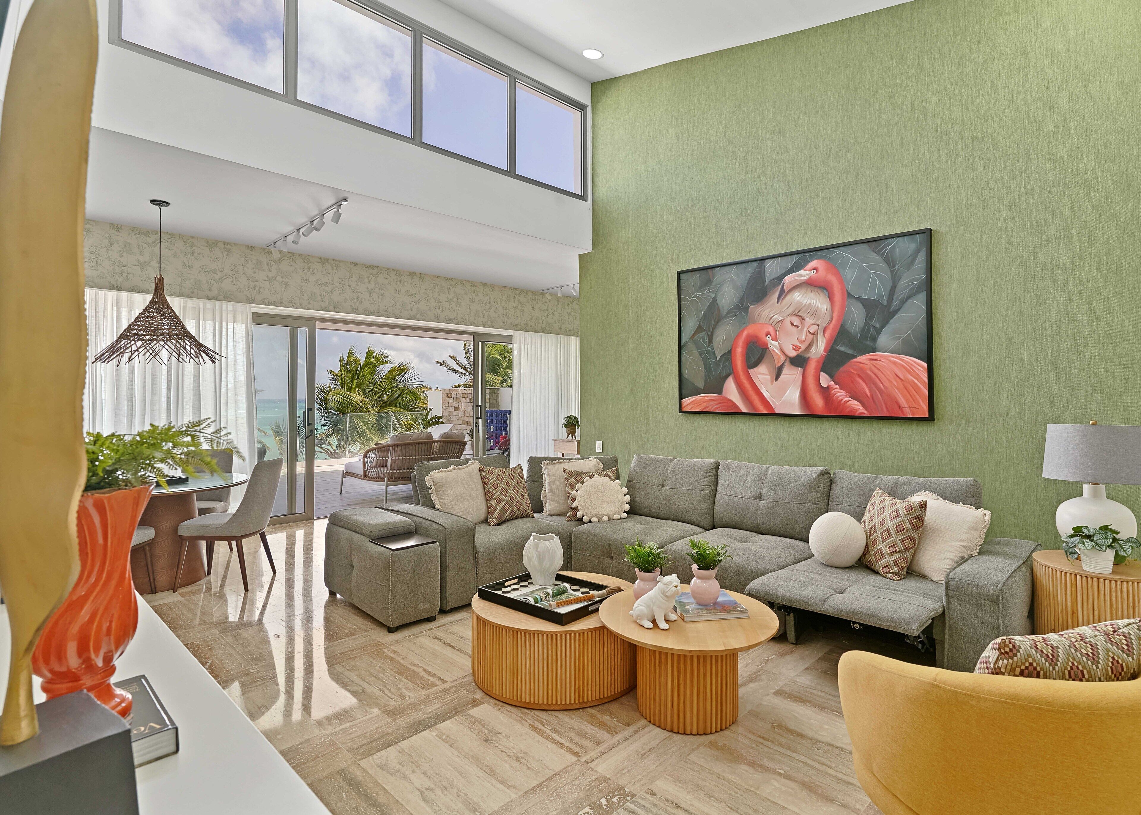 A spacious living room with a large sofa, a coffee table, and a dining area with a table and chairs.