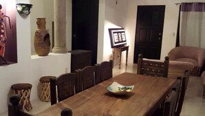 A dining area with a wooden table, chairs, and a vase on the wall. - Casa San Miguel 4479 (Mexico City)