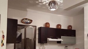 A compact kitchen with dark cabinets, a stove, and a sink. - Casa San Miguel 4479 (Mexico City)