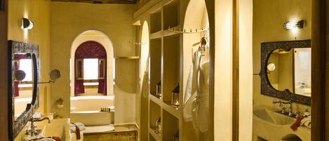 Ein Badezimmer mit Badewanne, Waschbecken, Spiegel und einem Fenster mit Blick.