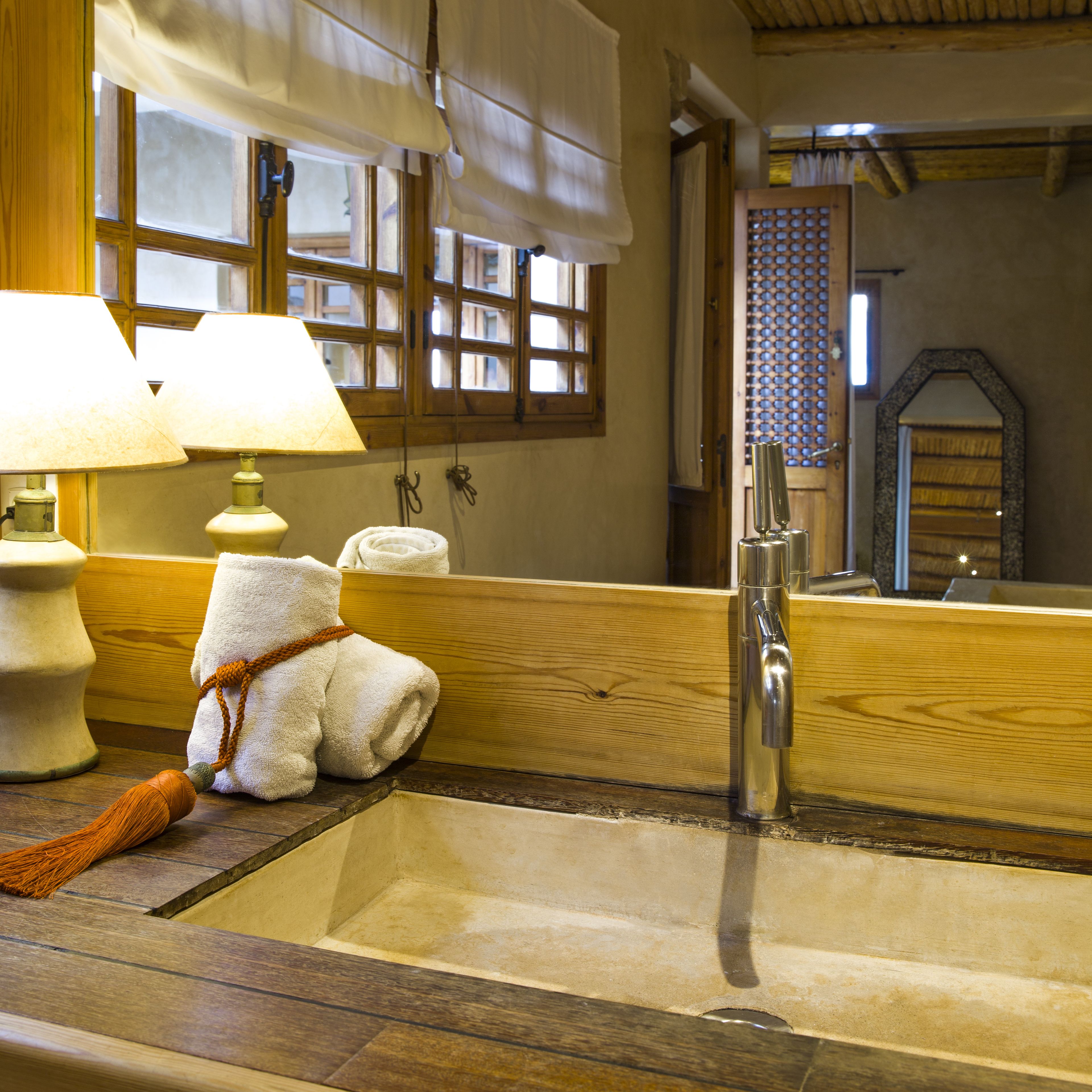 Une salle de bain avec un meuble-lavabo en bois, un évier, un miroir et une serviette accrochée au mur.