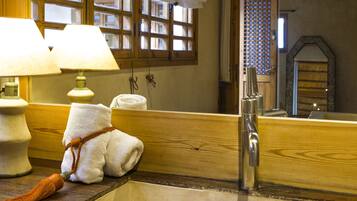 Une salle de bain avec un meuble-lavabo en bois, un évier, un miroir et une serviette accrochée au mur.