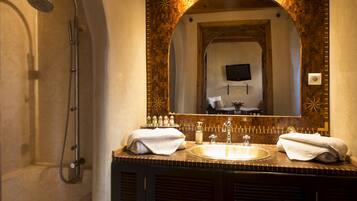 A bathroom with a shower, a sink, and a mirror.