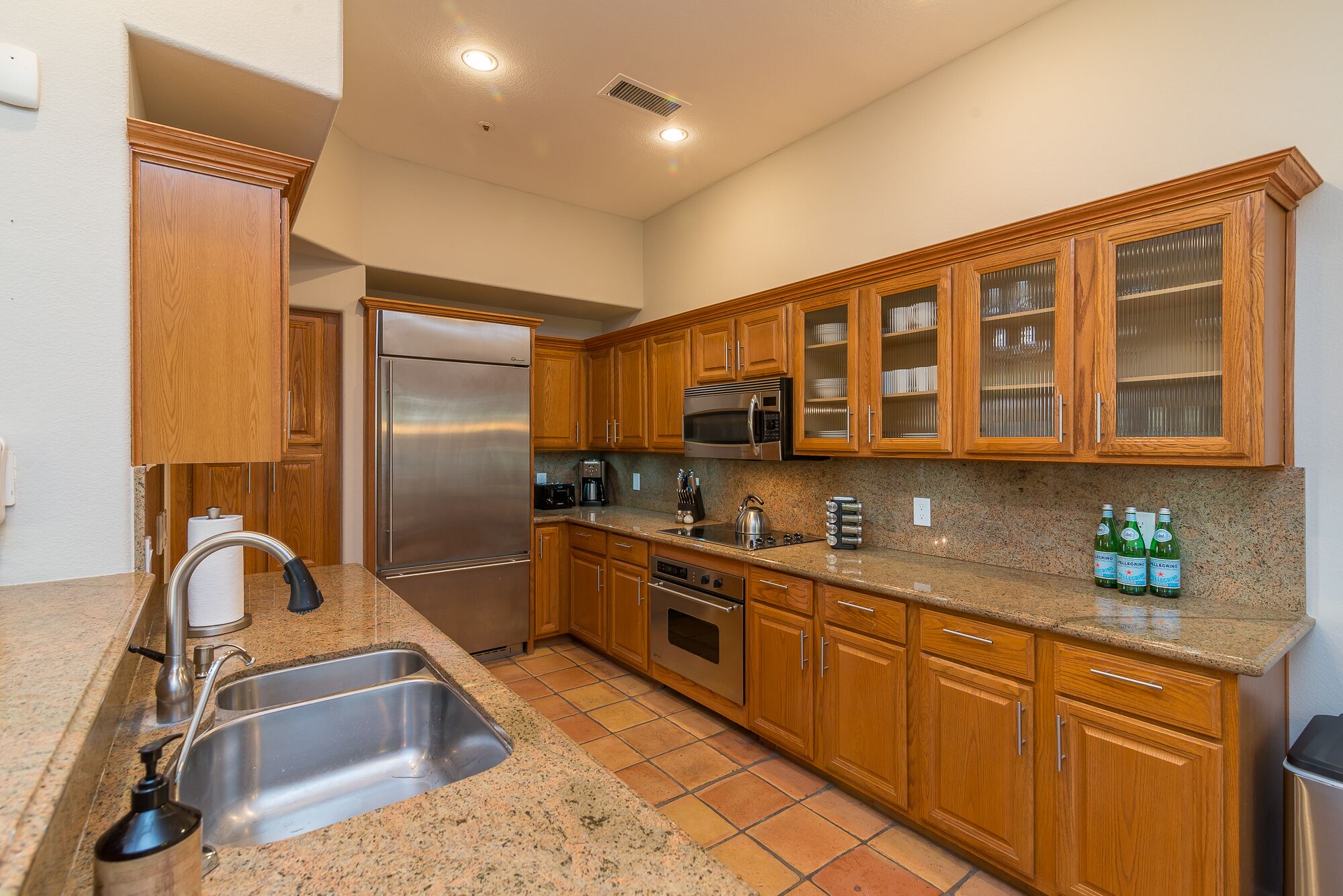 A kitchen with wooden cabinets, stainless steel appliances, and a granite countertop.