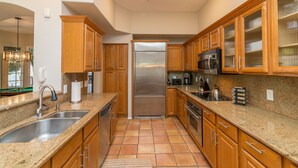 A kitchen with wooden cabinets, granite countertops, stainless steel appliances, and a tiled floor. - Casa Delight (Scottsdale)