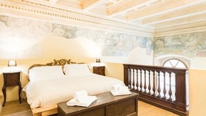 A bedroom with a bed, a nightstand, a wooden bench, and a balcony with a balustrade. - "Botticelli","Donatello"&"Dante"apartments by WP Relais in the heart of Florence (Firenze)