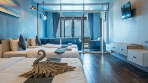 A hotel room with two beds, a balcony, a TV, and a desk with a chair. - Sara Resort (Koh Rong Sanloem)