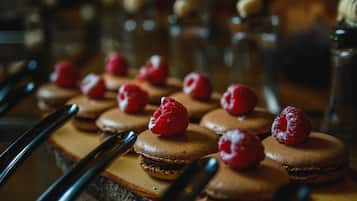 A dessert tray with macarons topped with raspberries.