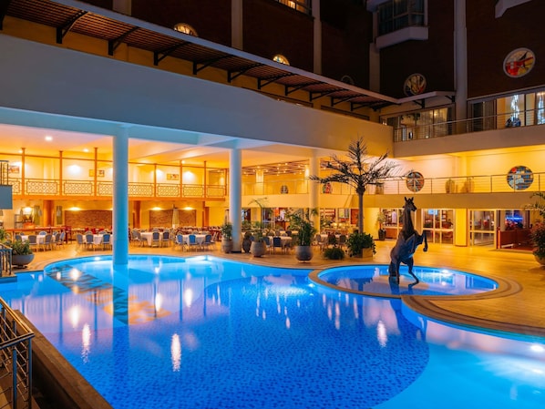 Una piscina al aire libre, sombrillas, tumbonas